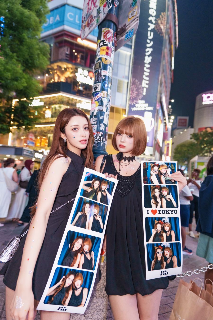 XL PHOTO STUDIOの長尺プリントを持って渋谷の街に立つ2人